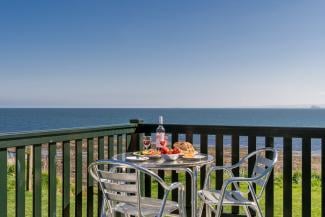 Breakfast on patio table decking with sea view