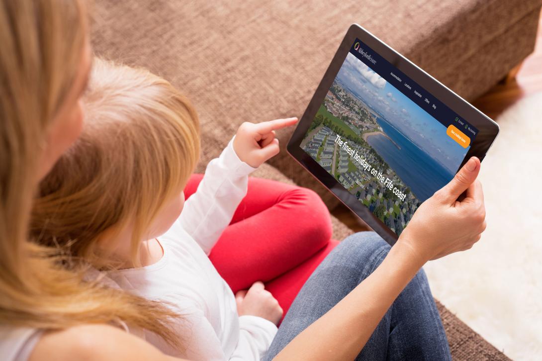Mother and child looking for holidays on tablet
