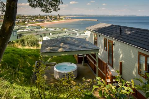 lodge with hot tub and sea views in dabbled sunlight