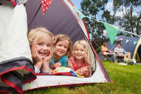 Children in looking out of a tent