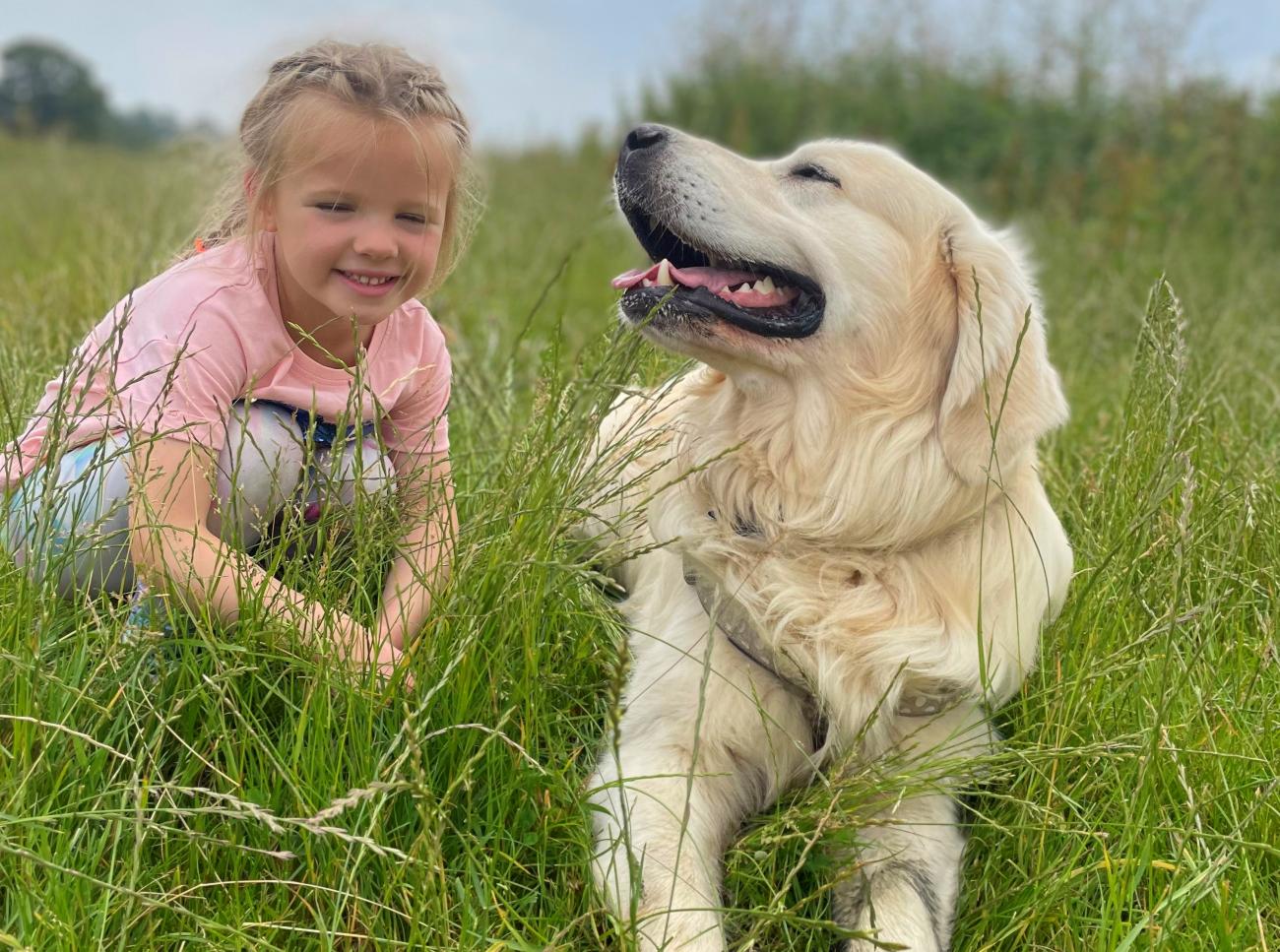 Happy girl and dog in the grass
