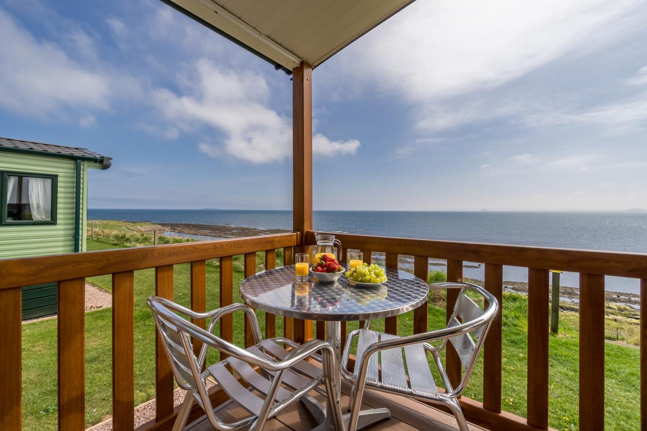 Breakfast on patio table decking with sea view