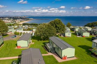 holiday homes on grass with sea in the distance