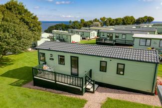 holiday homes on grass with sea in the distance