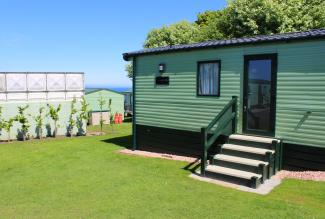 Signature Value holiday home exterior on grass with blue sky