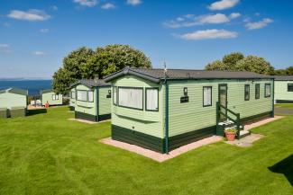 holiday homes on grass with sea in the distance