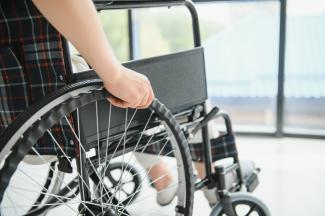 Close up of hand on wheel chair wheel