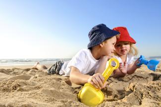 Children making sandcastles on a beach on a sunny day