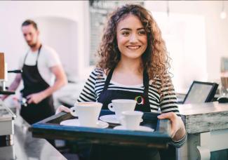 Waitress carrying a tray of hot drinks