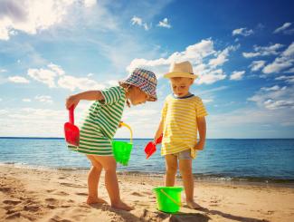 Children making sandcastles on a beach on a sunny day