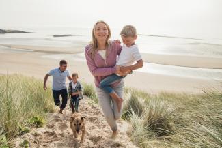 family walking through sand dunes
