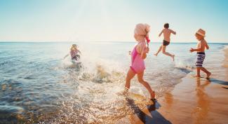 Children running into the sea on a sunny day