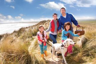 Family walking dog on the coastal path